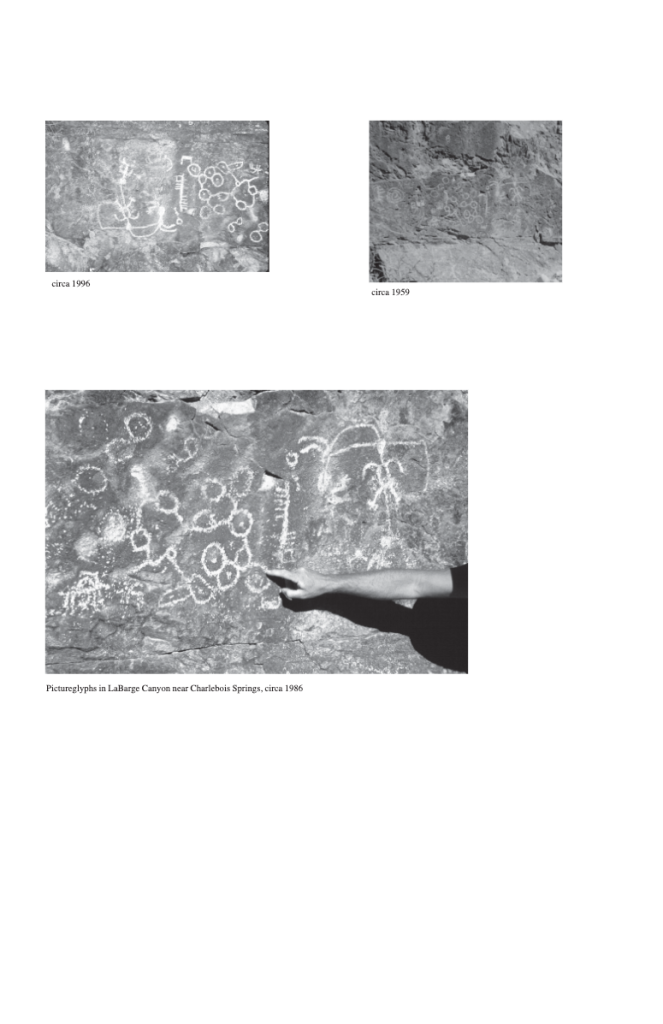 Petroglyphs on rock surfaces, with a hand pointing to them
